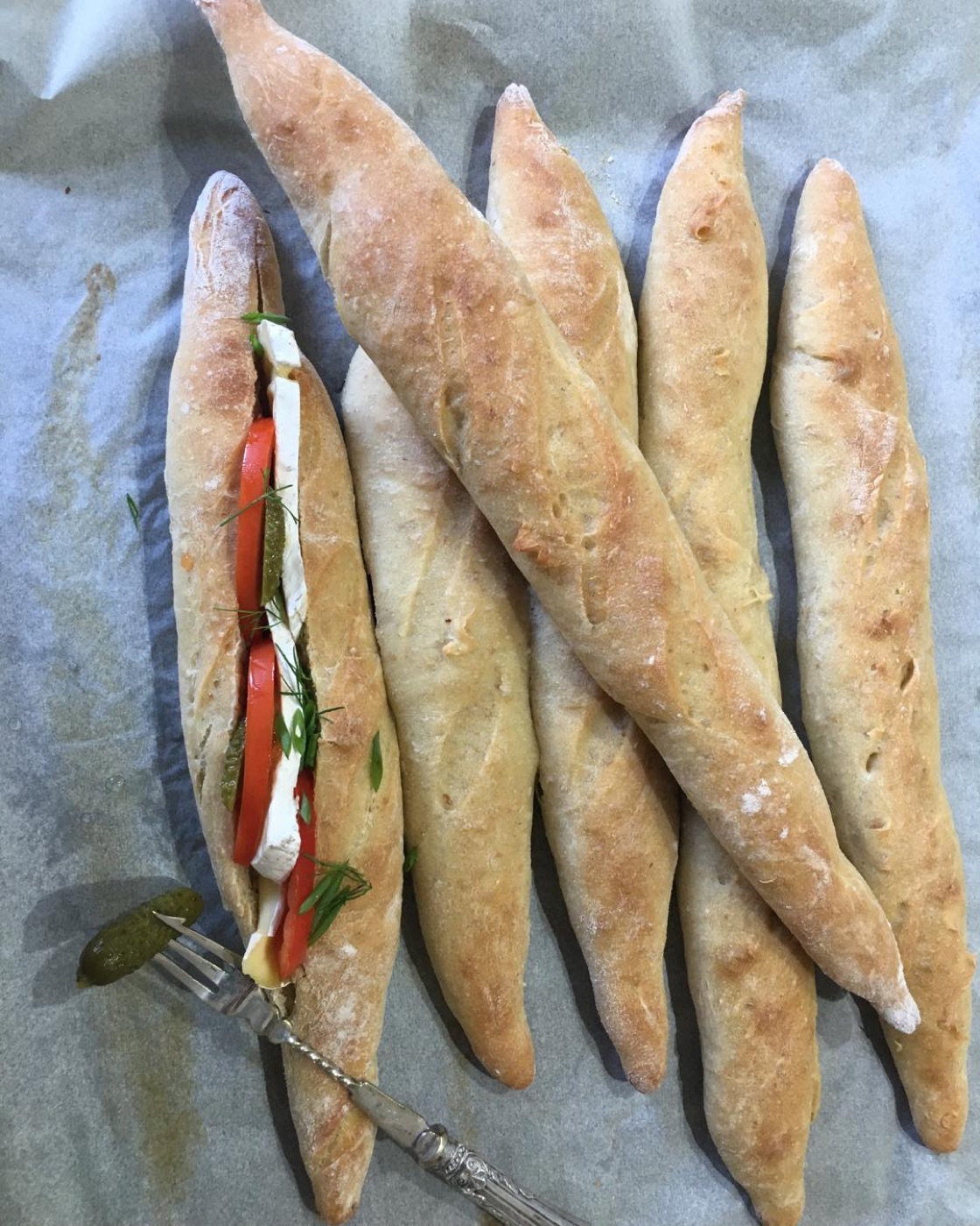 Little ficelle loaves, one filled with tomato and mozzarella