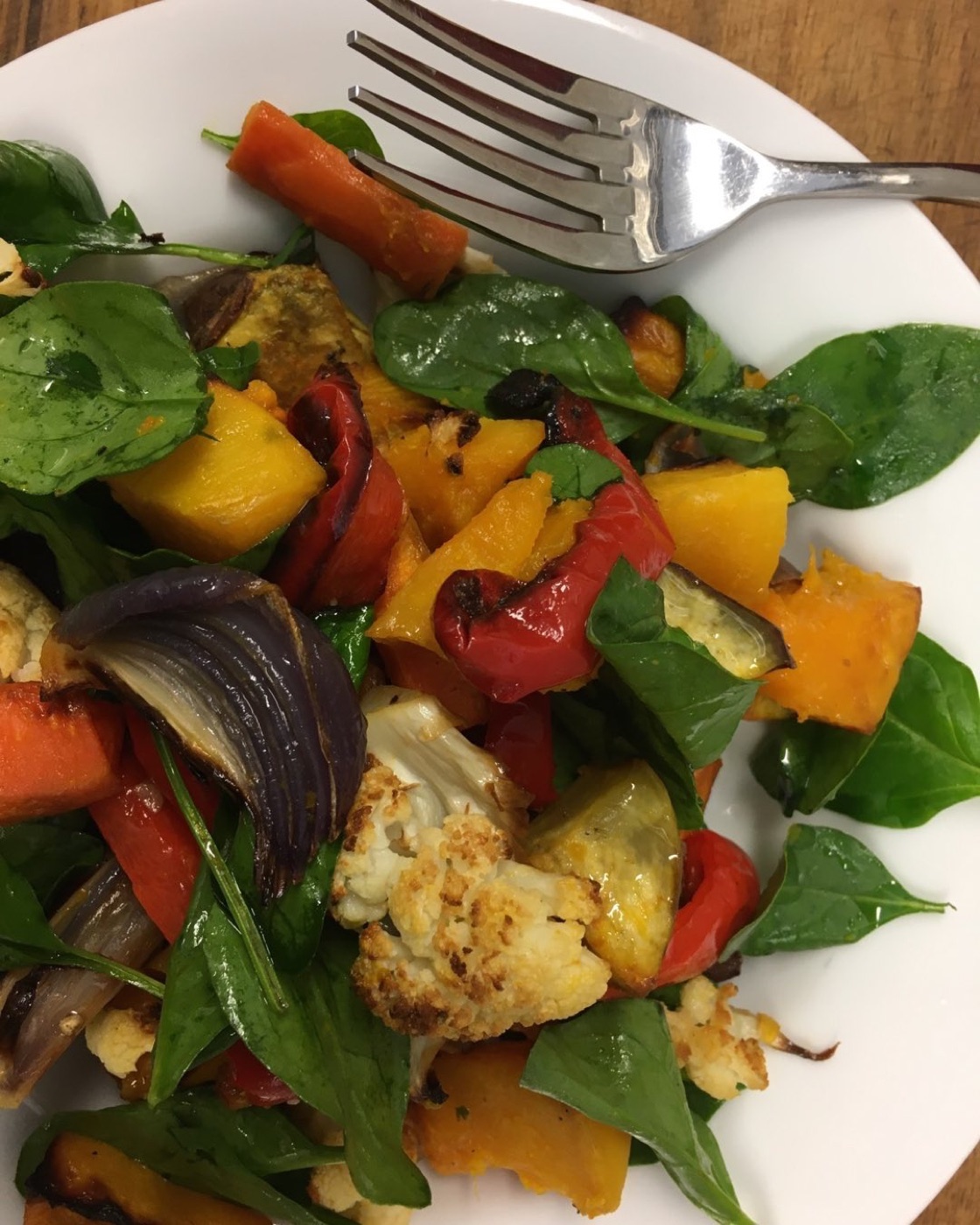 Roast pumpkin, carrot, cauliflower and red onion on baby spinach
